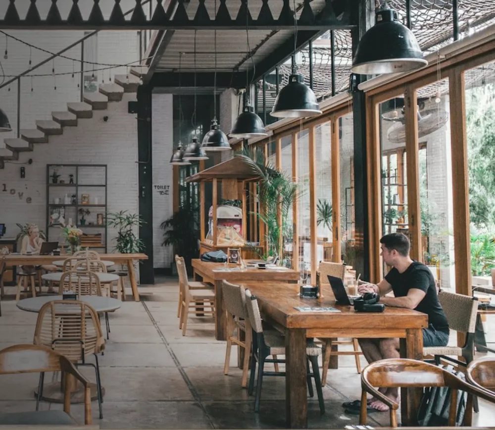 Salón de Café Ka'a con mesas de madera y luz natural